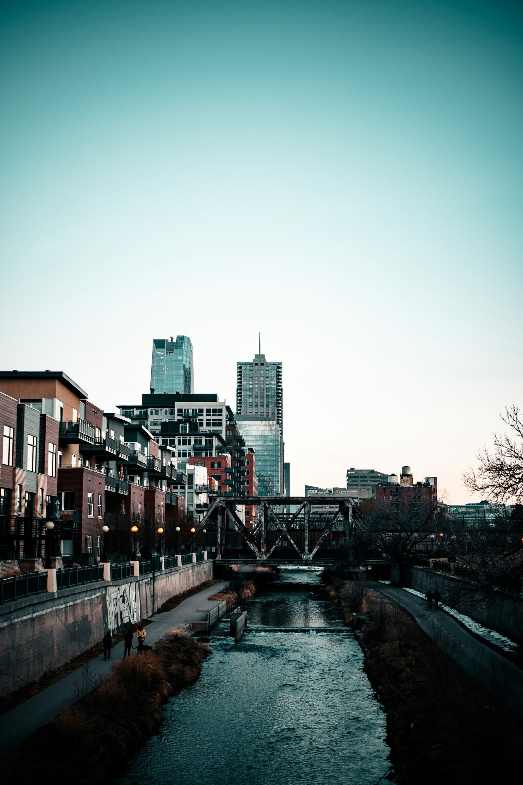 Urban skyline with river and pedestrian path